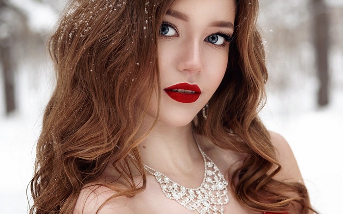 Woman with red lipstick and diamond necklace in snow