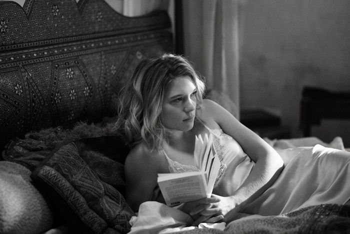 Léa Seydoux reading a book in bed