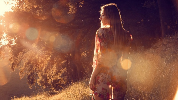 Woman in floral dress in golden hour sunlight