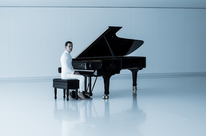 Michael Fassbender sitting at a Steinway grand piano