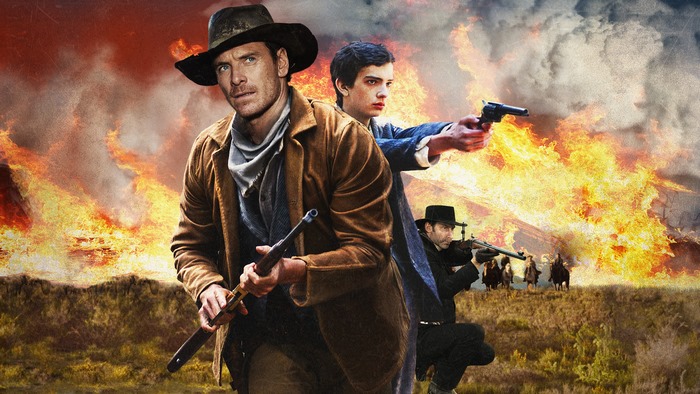 Michael Fassbender and others in a Western scene with fire