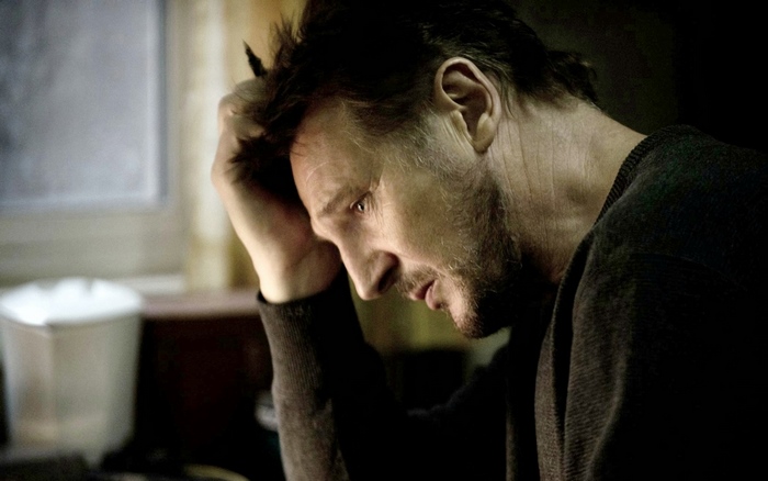Liam Neeson in a dark room