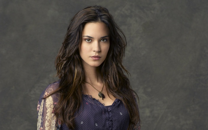 Woman with long brown hair wearing a necklace