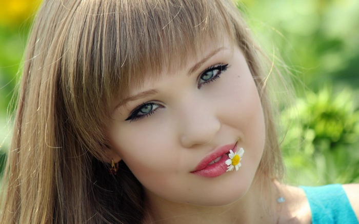 Young woman with a daisy in her mouth