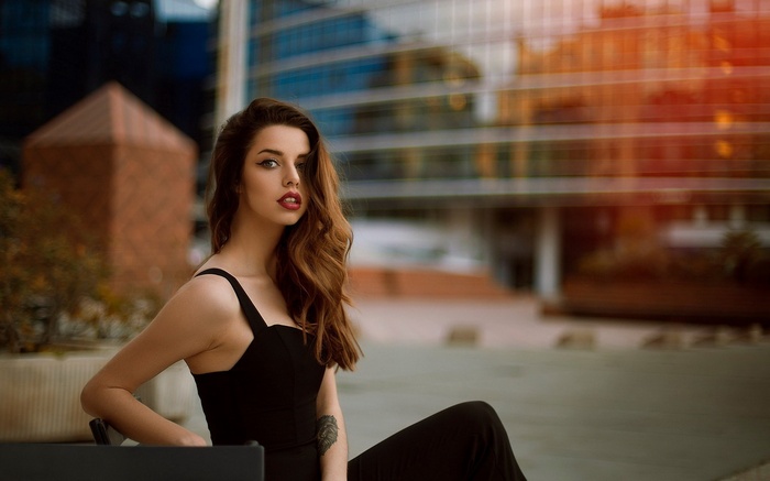 Woman in black dress posing outdoors