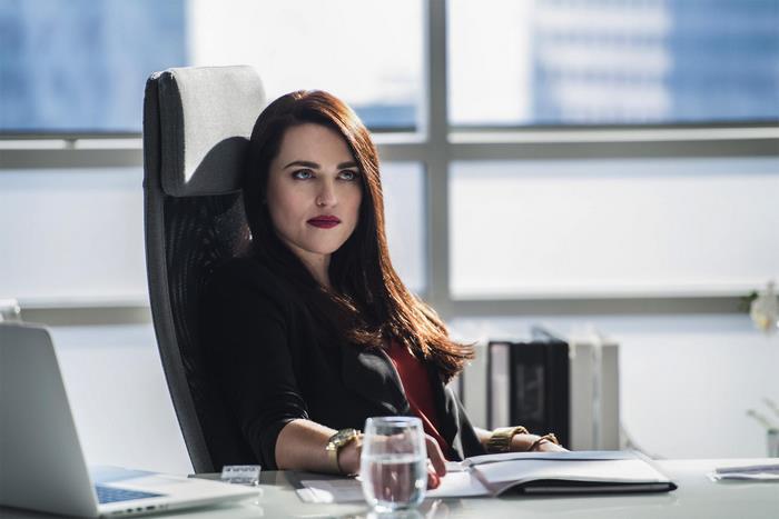 Katie McGrath sitting at a desk