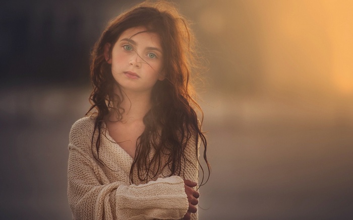 Young girl with long brown hair wearing a sweater