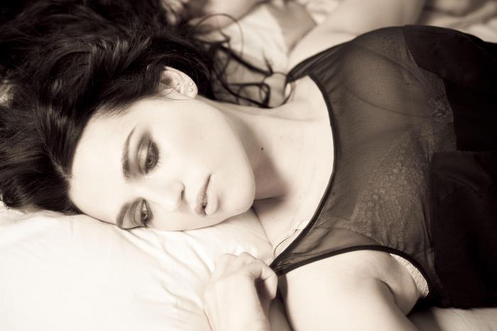 Katie McGrath lying on a bed