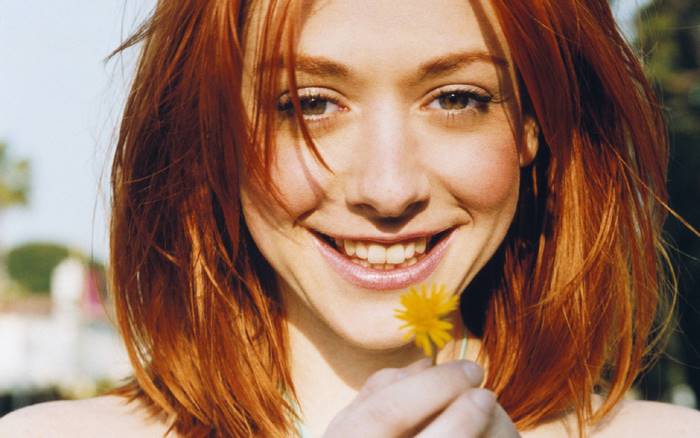 Alyson Hannigan holding a yellow flower