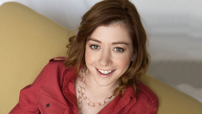 Alyson Hannigan sitting on a yellow couch