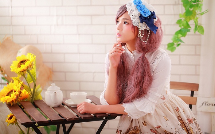 Woman in Lolita dress with sunflowers and tea set