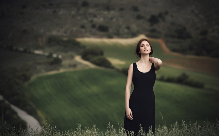 Woman in black dress in a field