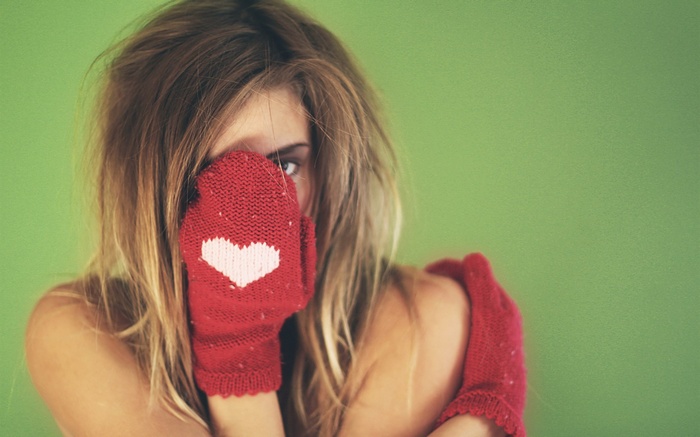 Woman wearing red mittens with heart