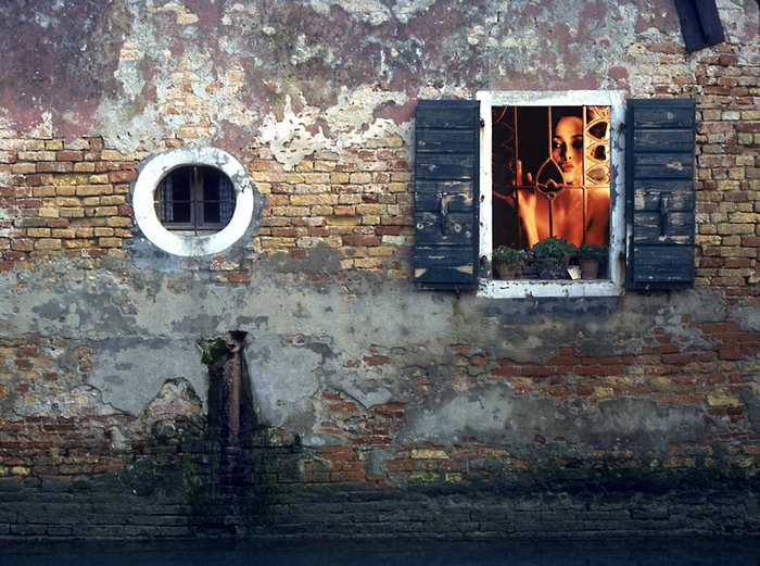 Woman in window of old brick building