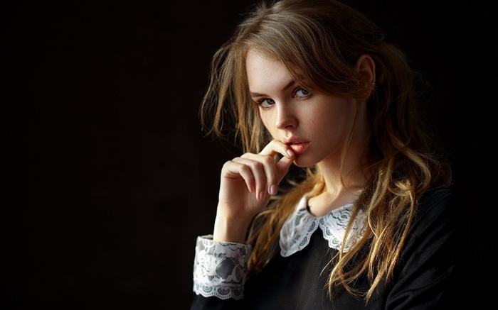 Young woman with blonde hair in black dress