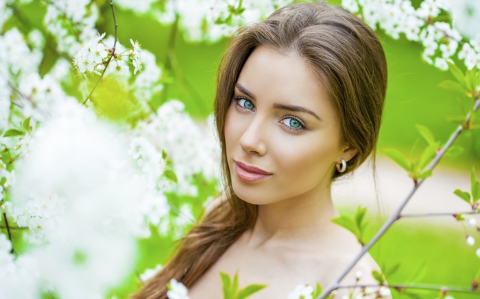 Woman with blue eyes among white flowers