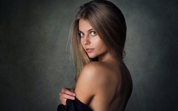 Woman with blonde hair looking over her shoulder