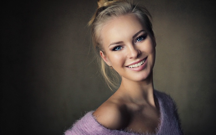 Woman with blonde hair and blue eyes smiling