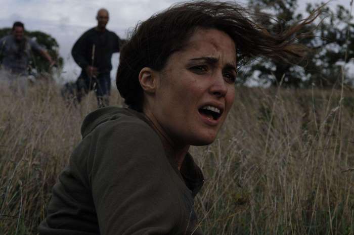 Rose Byrne in a field with pursuers