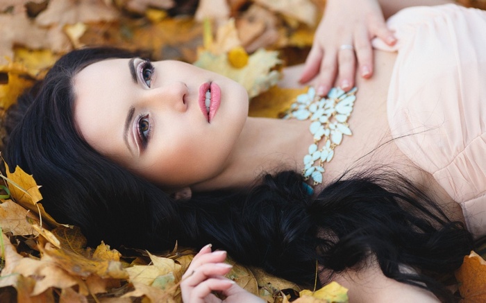 Woman lying in autumn leaves