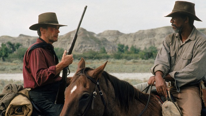 Two men on horses with rifles