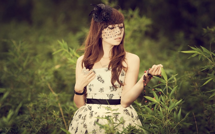 Woman in a floral dress and veil in a garden