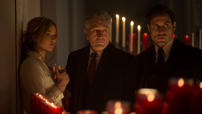 Robert De Niro and two others in front of candles