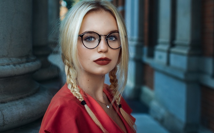 Woman with blonde braids and glasses