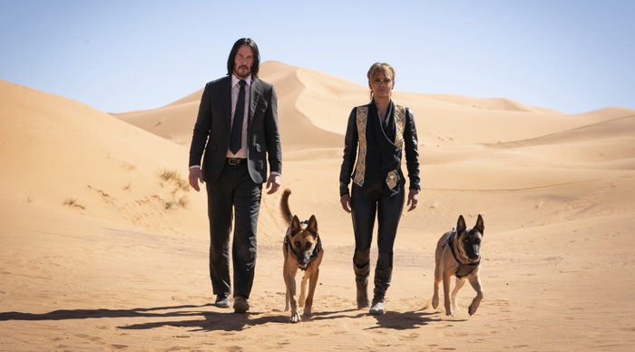 Keanu Reeves and Halle Berry with dogs in desert