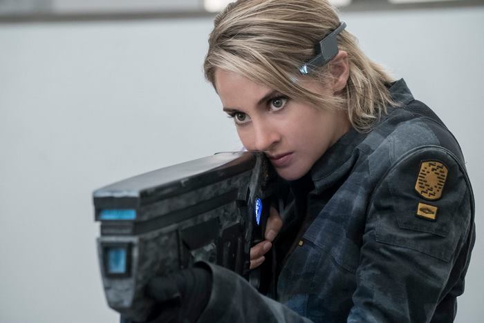 Shailene Woodley holding a futuristic weapon