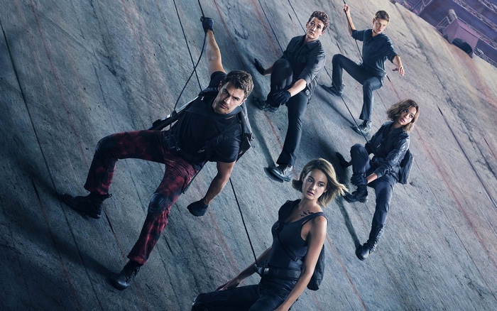 Four Divergent characters climbing a wall
