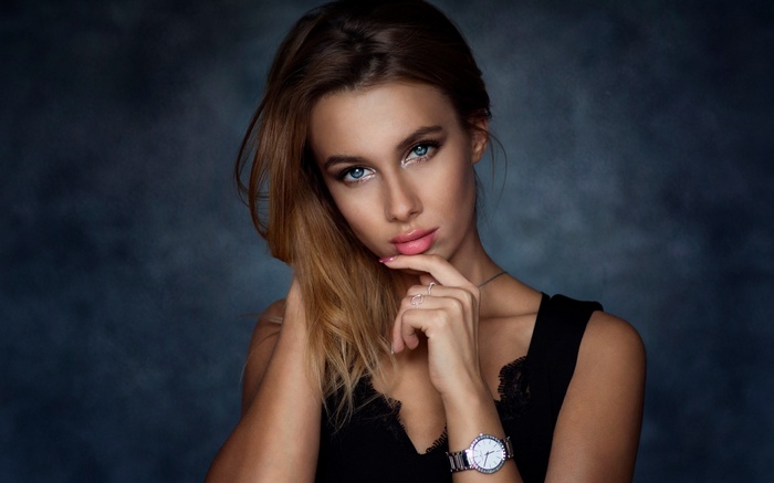 Woman with blue eyes and blonde hair wearing a black top