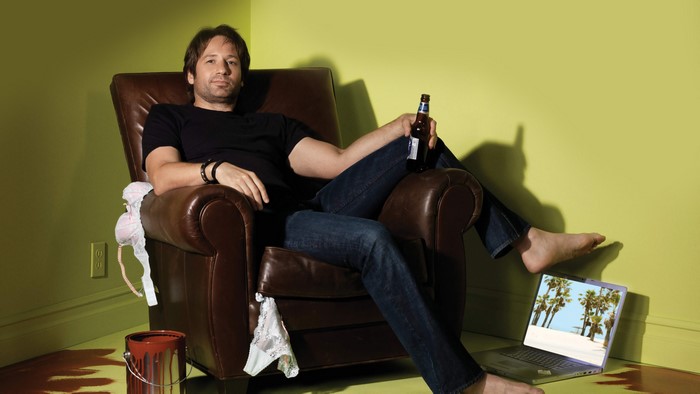 David Duchovny sitting in a chair with a beer