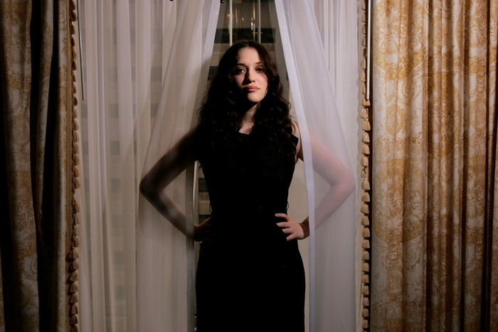 Kat Dennings standing between curtains