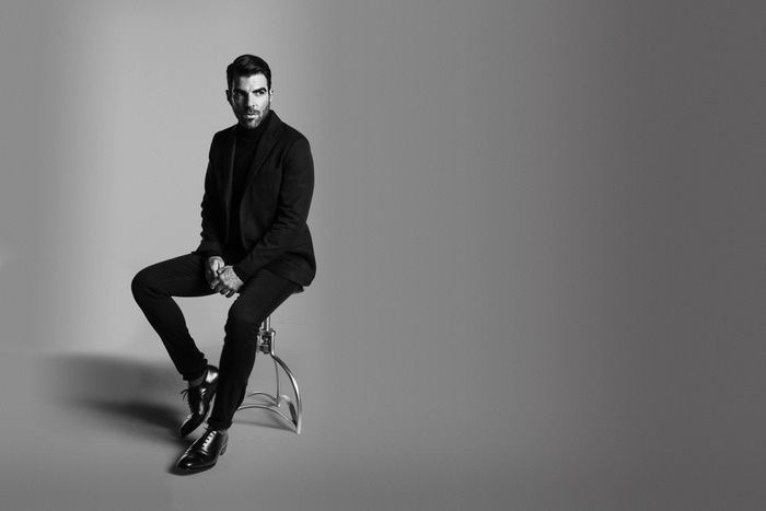 Zachary Quinto sitting on a stool