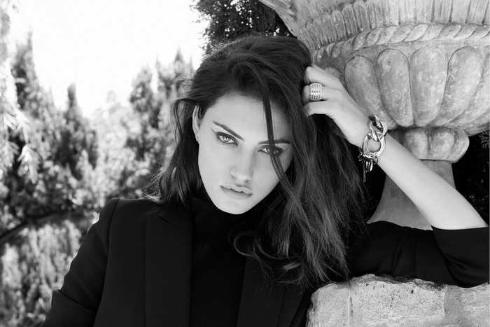 Phoebe Tonkin posing by a stone urn