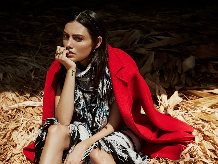 Phoebe Tonkin sitting in dried corn stalks