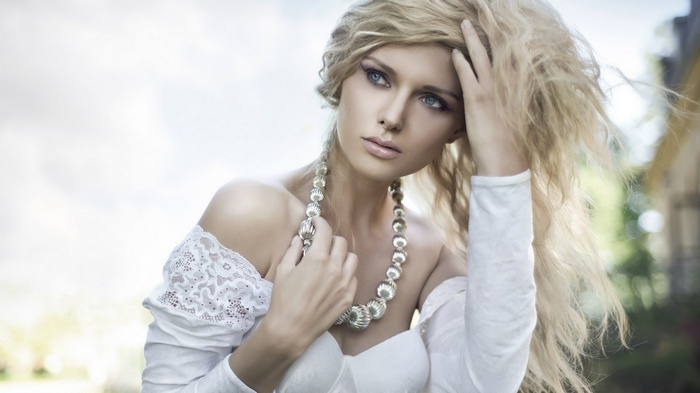 Woman with blonde hair and pearl necklace