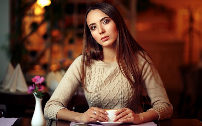 Woman in sweater holding a cup of coffee
