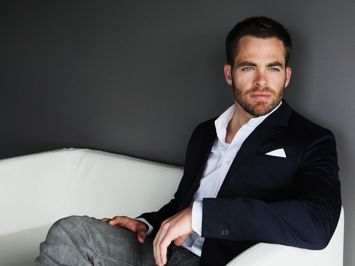 Chris Pine sitting on a white couch