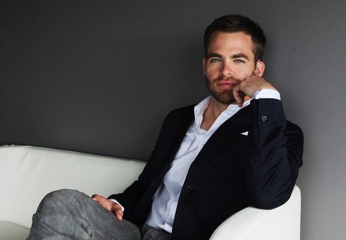 Chris Pine sitting on a white couch