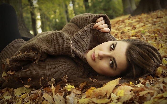 Woman lying in autumn leaves
