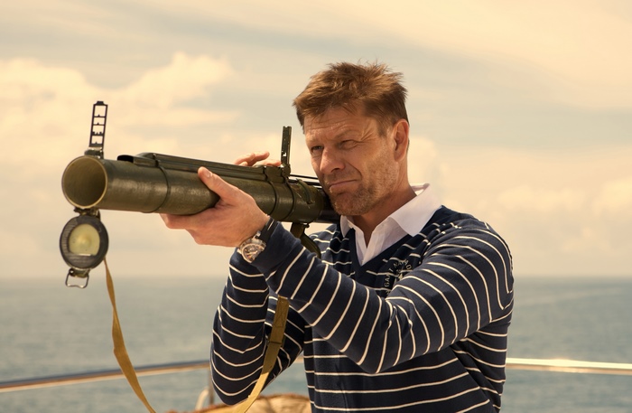 Sean Bean holding a rocket launcher on a boat