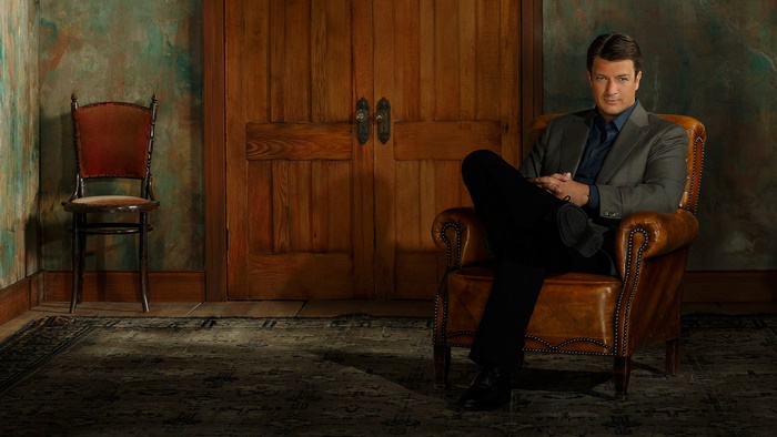 Nathan Fillion sitting in a leather chair