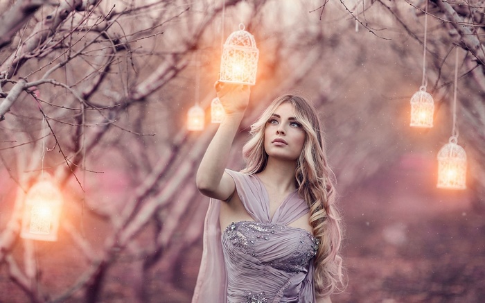 Woman holding a lantern in a magical forest