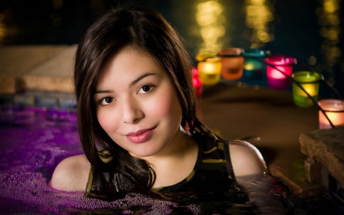 Miranda Cosgrove in a hot tub at night