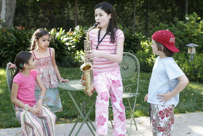 Miranda Cosgrove playing saxophone with children