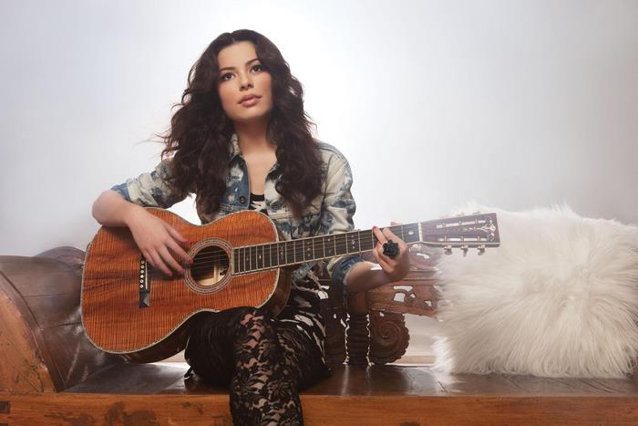 Miranda Cosgrove playing acoustic guitar