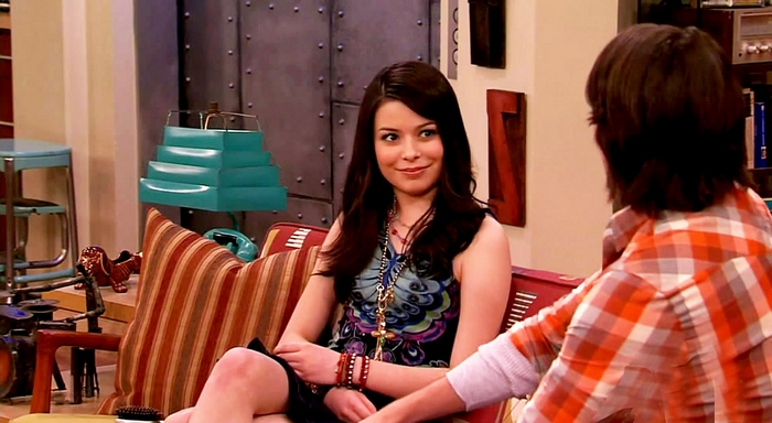 Miranda Cosgrove sitting on a couch