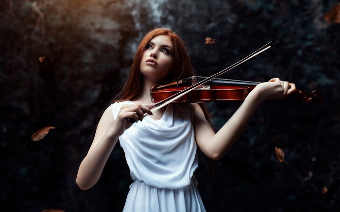 Woman playing violin in a dark forest